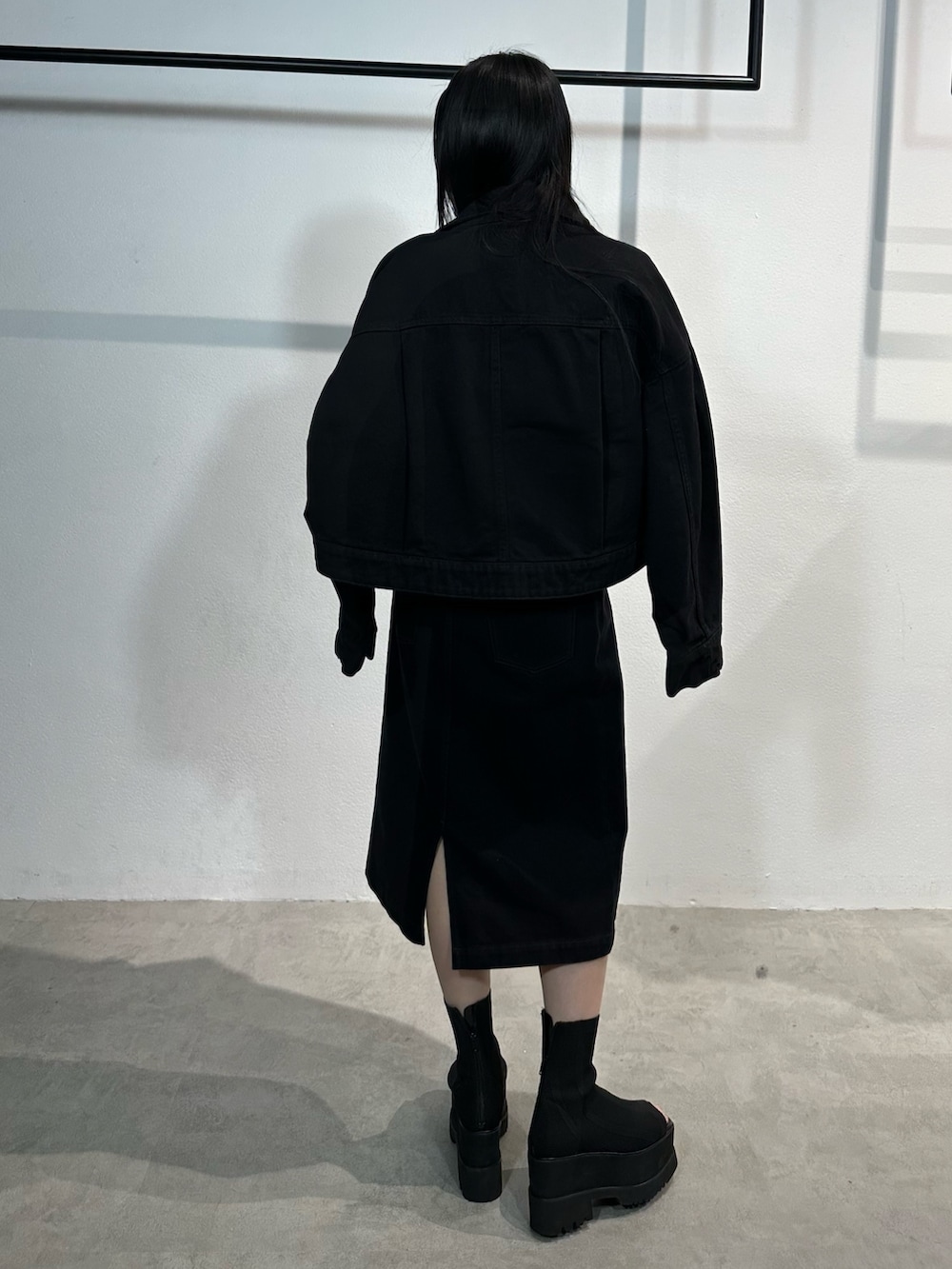 ブラック系のワンピース、ブラック系のデニムジャケット、ブラック系のブーツを着用したレディースの冬コーディネートの3枚目の写真