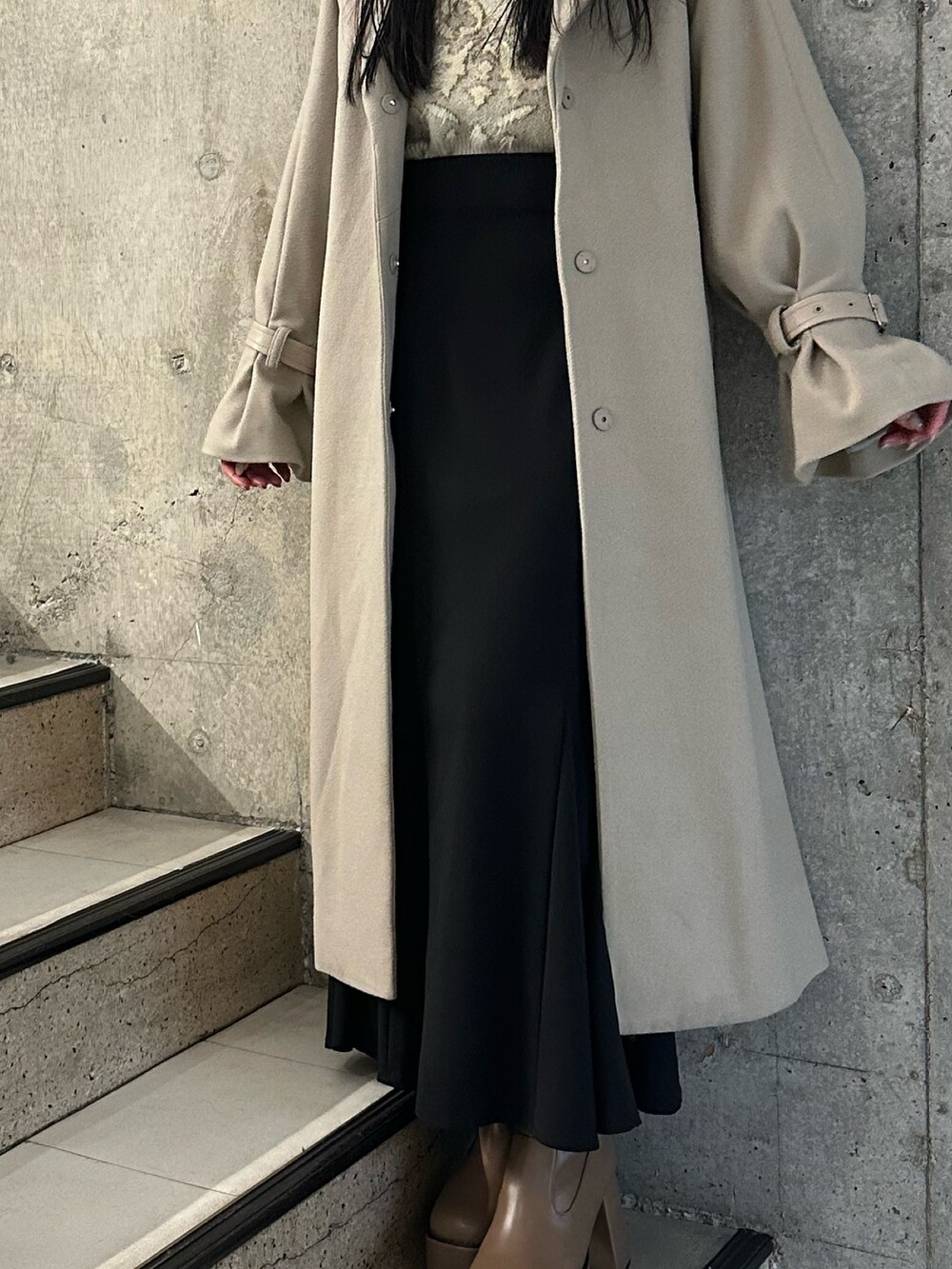 ブラック系のスカート、ホワイト系のニット/セーター、ブラウン系のブーツを着用したレディースの冬コーディネートの8枚目の写真