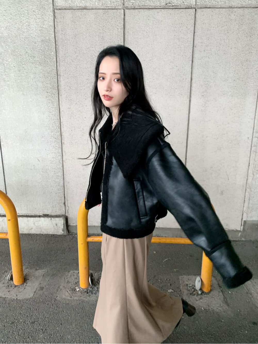 ブラウン系のスカート、ブラック系のブーツ、ブラック系のニット/セーターを着用したレディースの秋コーディネートの6枚目の写真