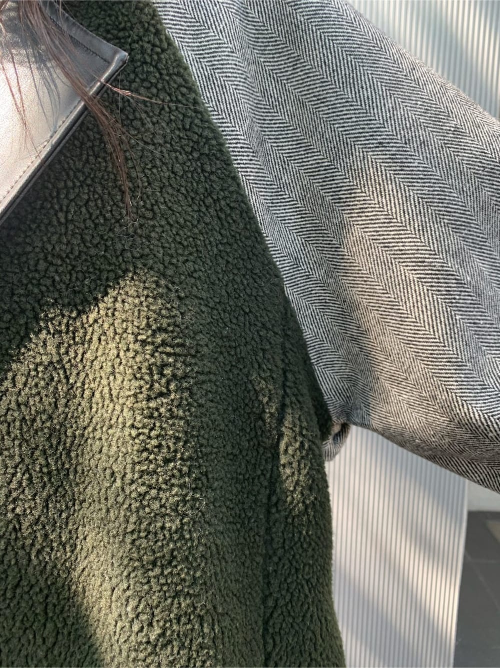 ブラック系のチェスターコート、ブラック系のワンピース、ブラック系のブーツを着用したレディースの秋コーディネートの5枚目の写真