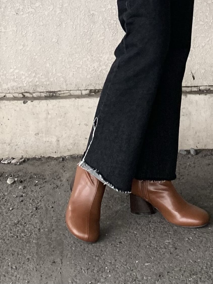 ブラック系のデニムパンツ、ブラウン系のブーツ、ブラック系のライダースジャケットを着用したレディースの秋コーディネートの5枚目の写真