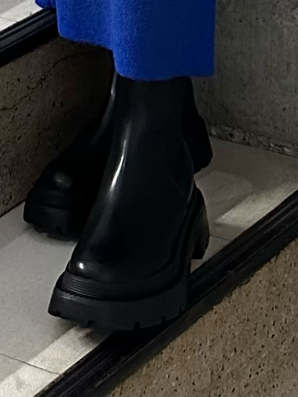 ブルー系のニット/セーター、ブルー系のスカート、ブラック系のブーツを着用したレディースの冬コーディネートの8枚目の写真