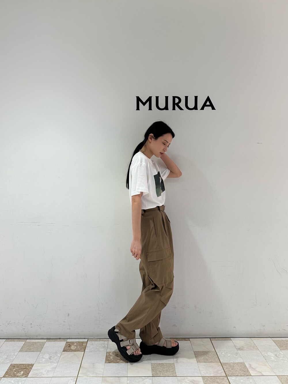 グリーン系のカーゴパンツ、ホワイト系のTシャツ/カットソー、ベージュ系のサンダルを着用したレディースの春コーディネートの2枚目の写真