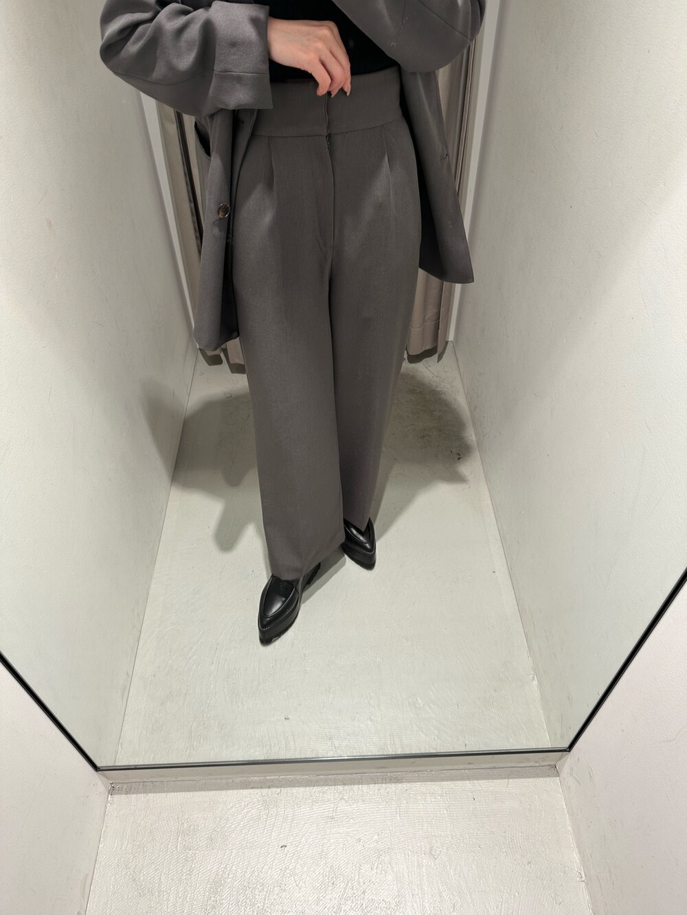 グレー系のスラックス、グレー系のテーラードジャケット、ブラック系のローファーを着用したレディースの冬コーディネートの3枚目の写真