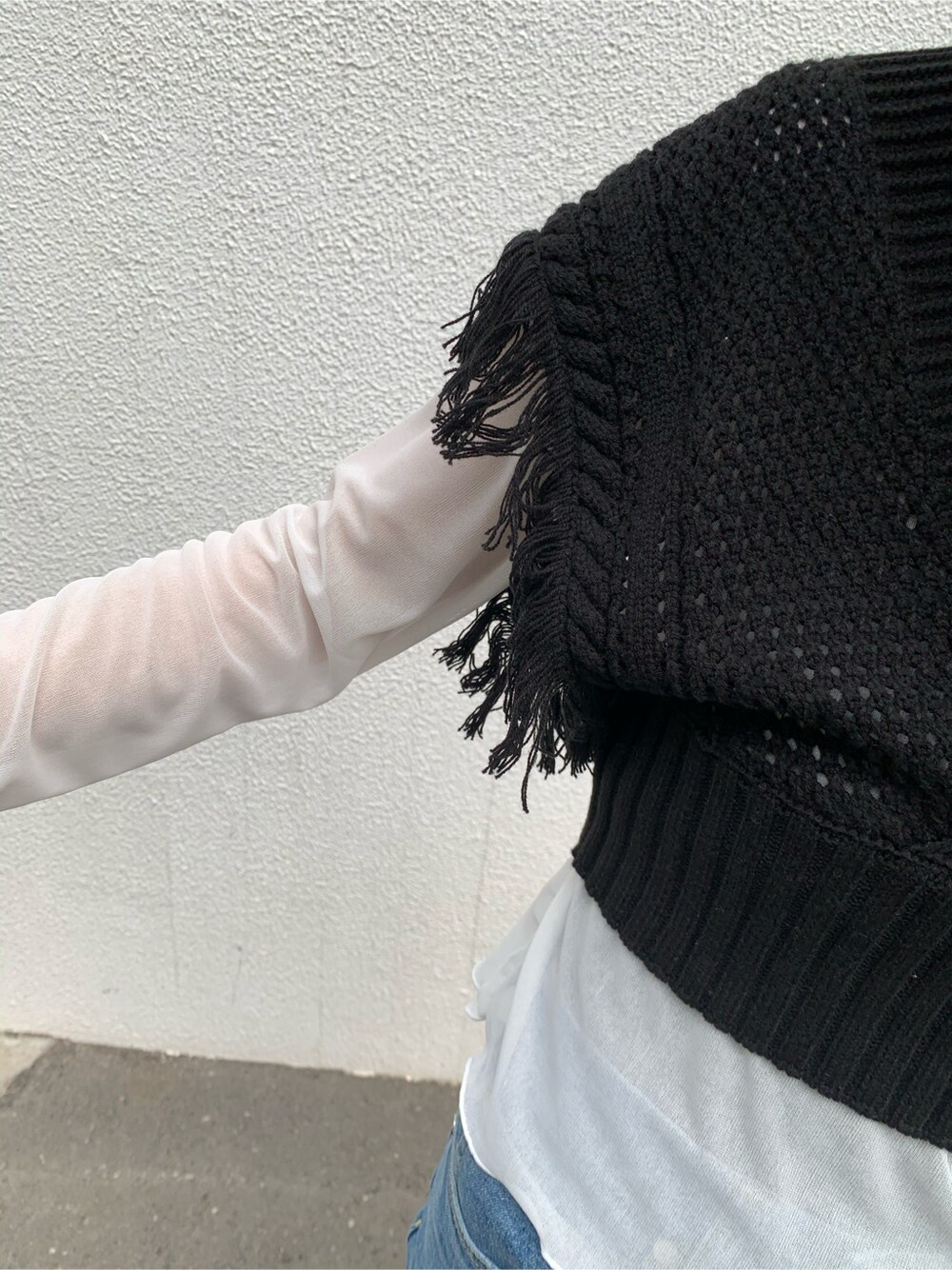 ブルー系のデニムパンツ、ブラック系のサンダル、ブラック系のニット/セーターを着用したレディースの春コーディネートの5枚目の写真