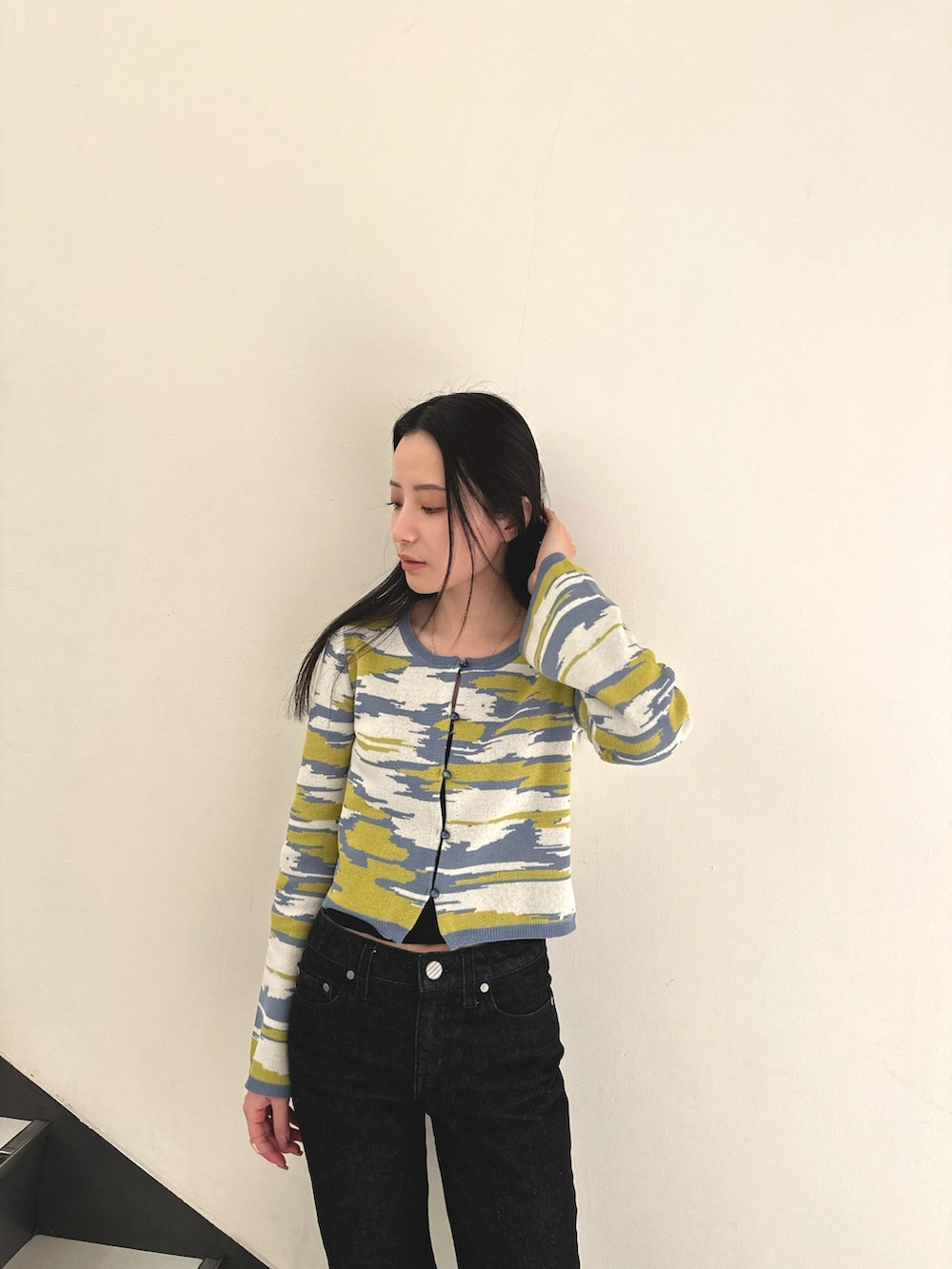 イエロー系のカーディガン/ボレロ、ブラック系のデニムパンツ、ホワイト系のローファーを着用したレディースの冬コーディネートの3枚目の写真