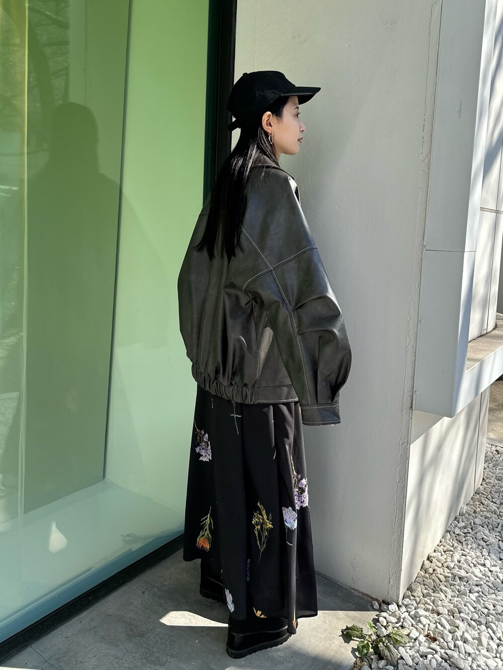 グレー系のブルゾン、ブラック系のスカート、ブラック系のブーツを着用したレディースの冬コーディネートの2枚目の写真