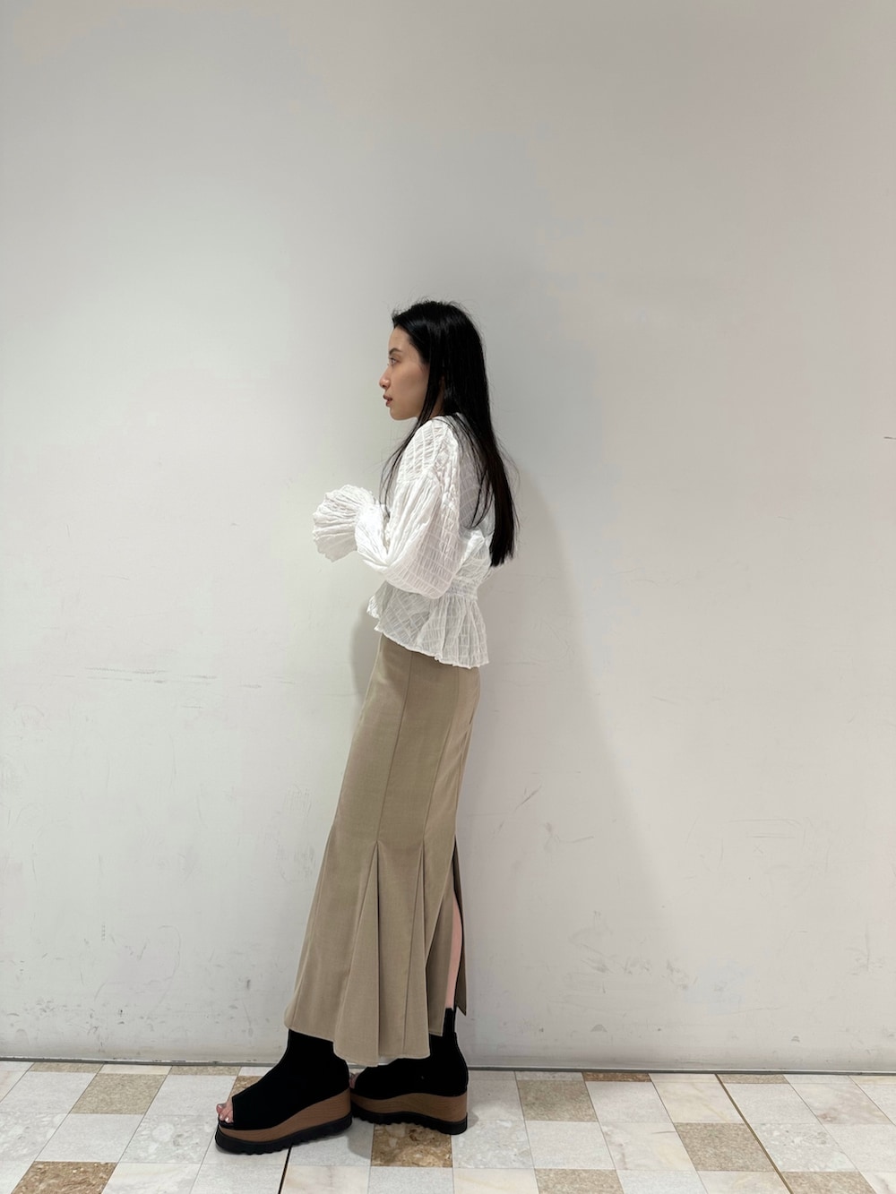 ホワイト系のシャツ/ブラウス、ベージュ系のスカート、ブラック系のブーツを着用したレディースの春コーディネートの4枚目の写真