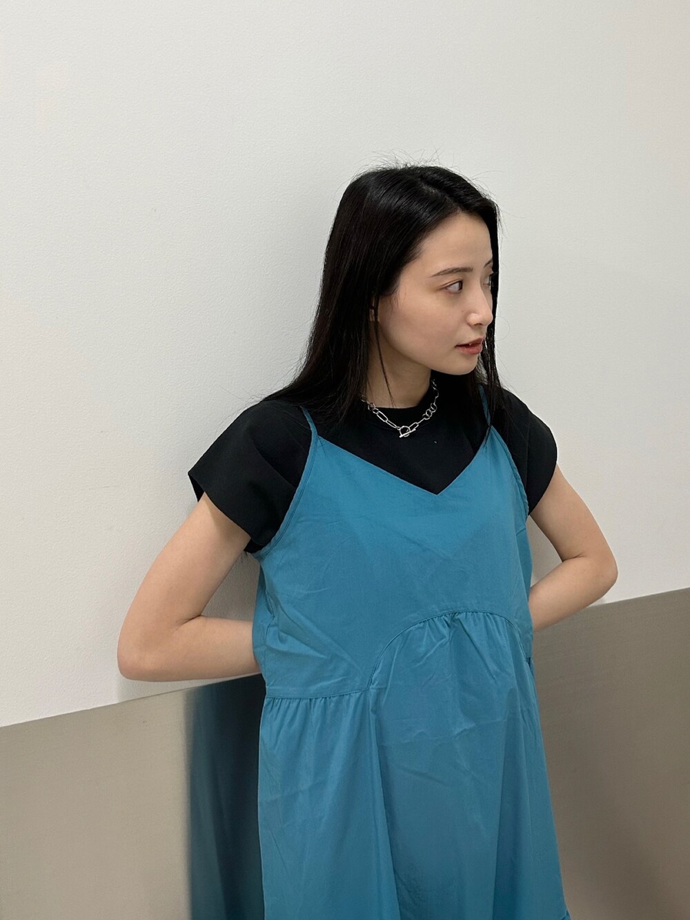 ブルー系のワンピース、ブラック系のTシャツ/カットソー、ブラック系のサンダルを着用したレディースの春コーディネートの4枚目の写真