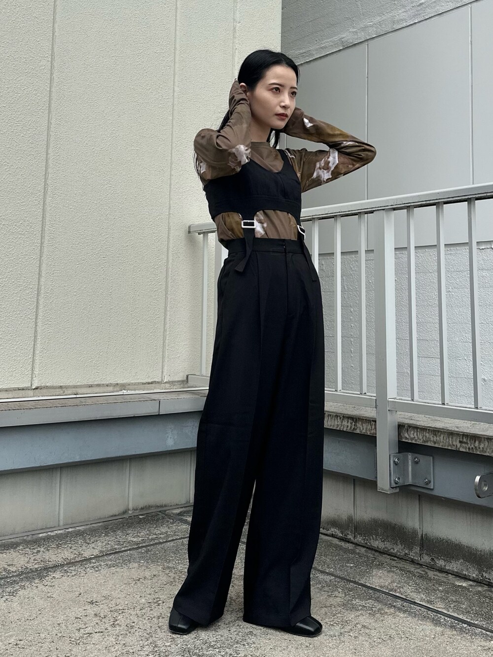 ブラック系のつなぎ/オールインワン、ブラウン系のTシャツ/カットソー、ブラック系のブーツを着用したレディースの秋コーディネートの2枚目の写真