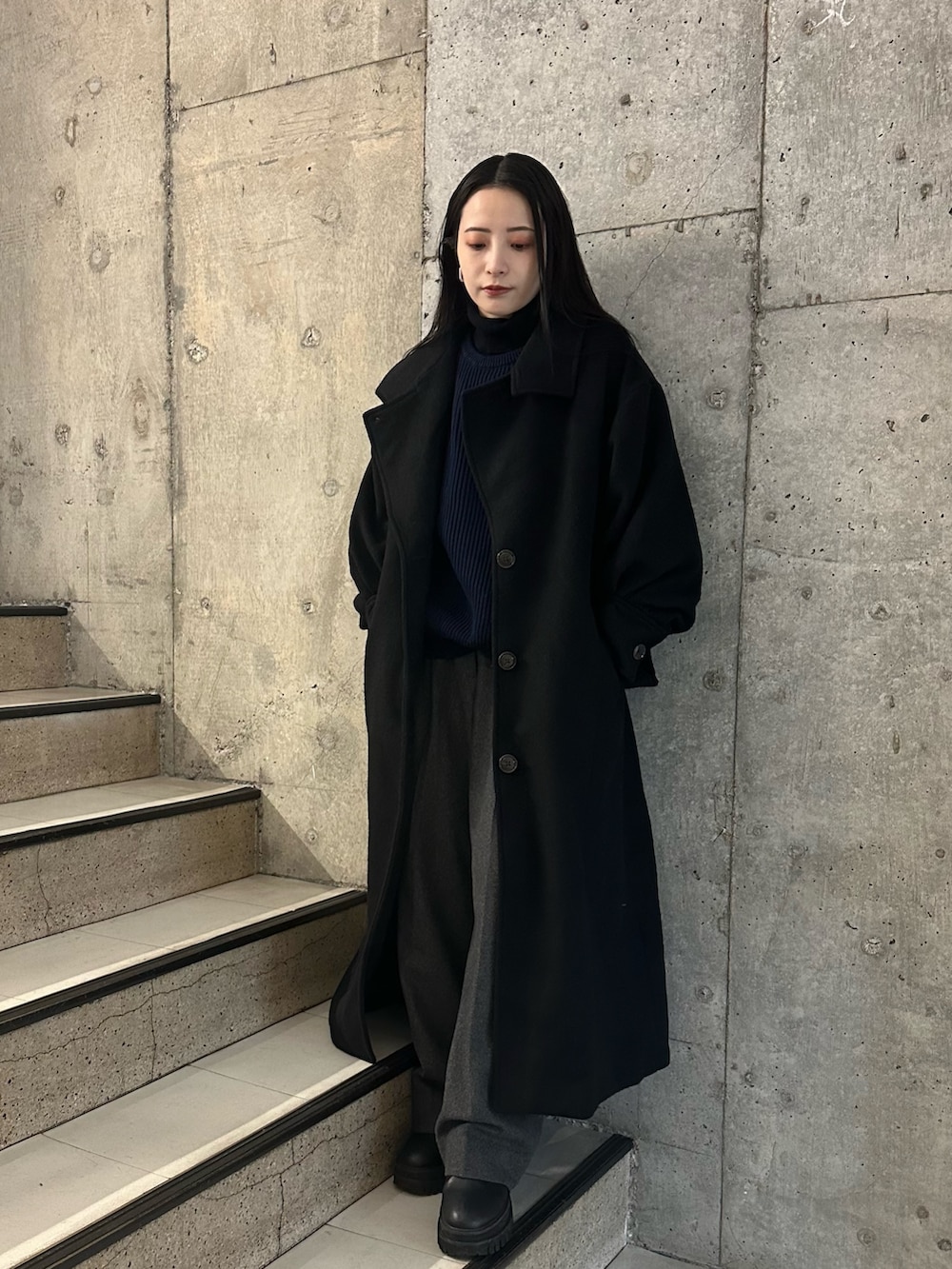 グレー系のスラックス、ブルー系のニット/セーターを着用したレディースの冬コーディネートの4枚目の写真