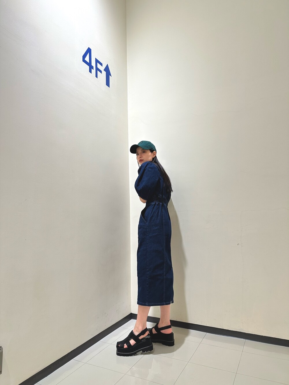 ブルー系のワンピース、ブラック系のサンダル、グリーン系のキャップを着用したレディースの春コーディネートの6枚目の写真