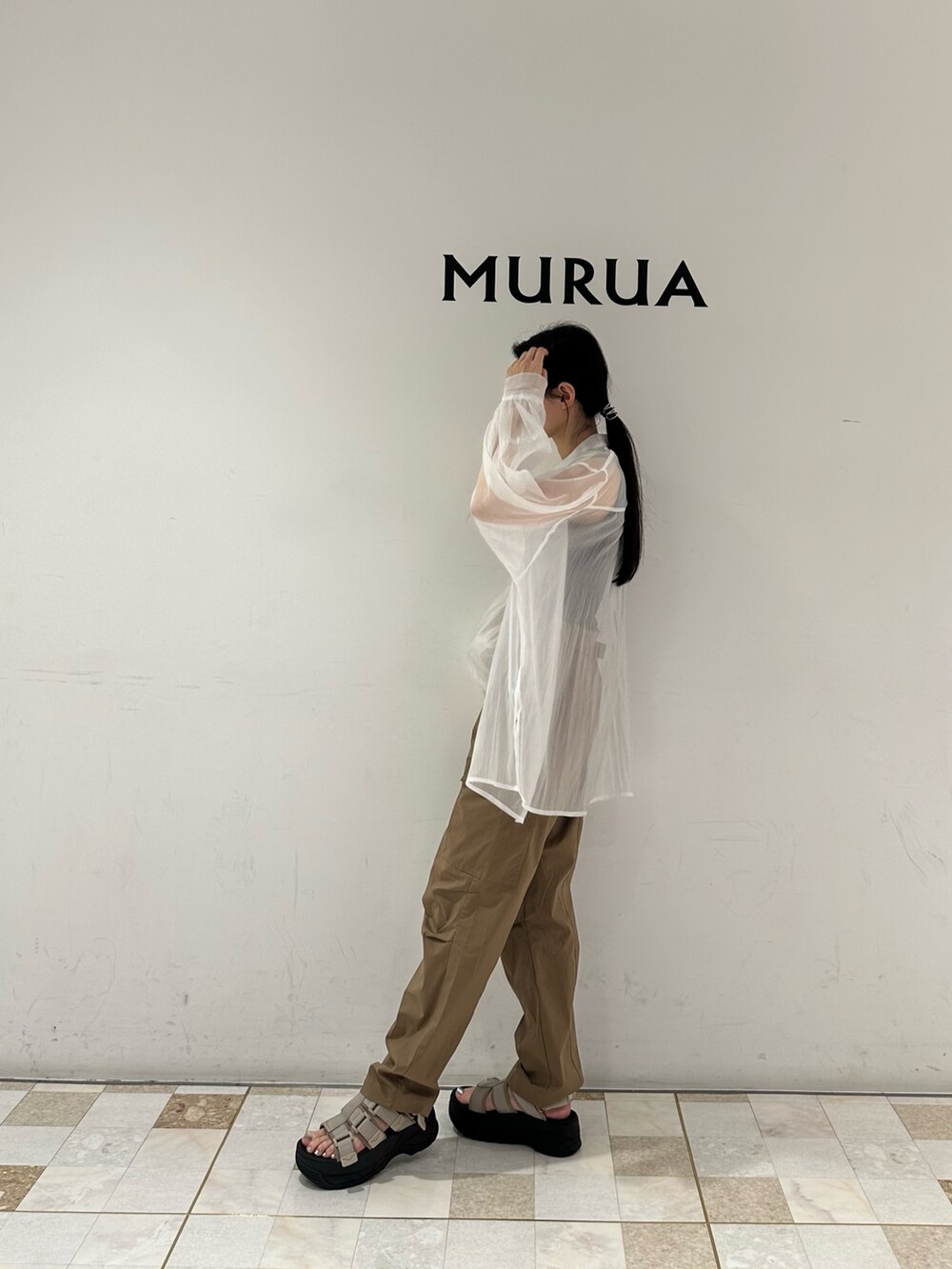 グリーン系のカーゴパンツ、ベージュ系のサンダル、ブラック系のタンクトップを着用したレディースの春コーディネートの3枚目の写真