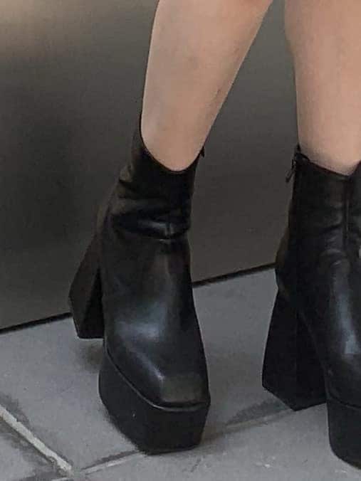 グリーン系のブルゾン、ブラック系のワンピース、ブラック系のブーツを着用したレディースの秋コーディネートの5枚目の写真