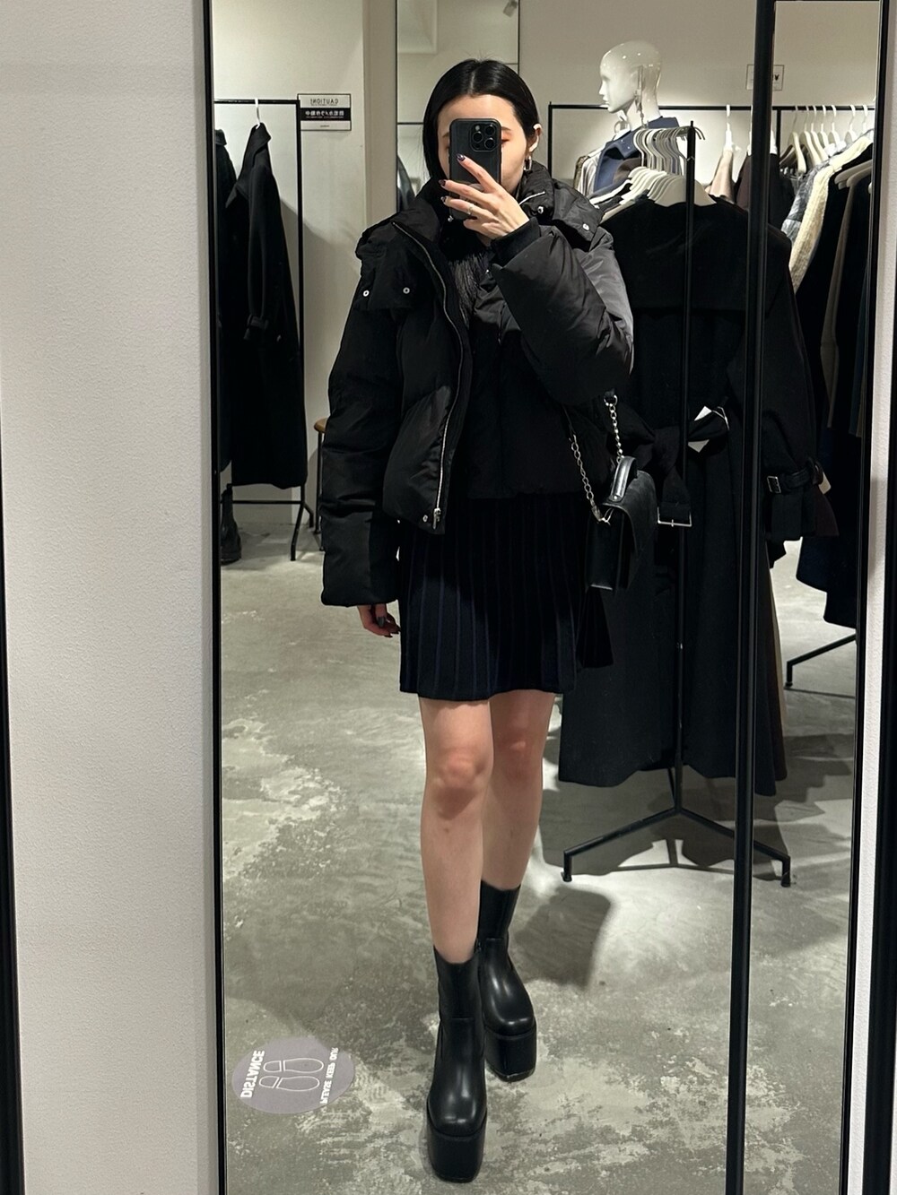 ブラック系のダウンジャケット/コート、ブラック系のブーツ、ブラック系のワンピースを着用したレディースの冬コーディネートの4枚目の写真