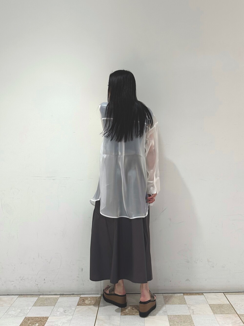 グレー系のスカート、ホワイト系のシャツ/ブラウス、ブルー系のタンクトップを着用したレディースの春コーディネートの3枚目の写真