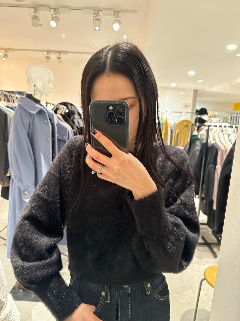 ブラック系のチェスターコート、ブラック系のブーツ、ブラック系のニット/セーターを着用したレディースの秋コーディネートの6枚目の写真