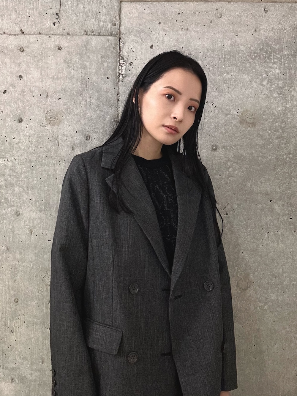 グレー系のスラックス、ブラック系のブーツ、グレー系のテーラードジャケットを着用したレディースの秋コーディネートの4枚目の写真