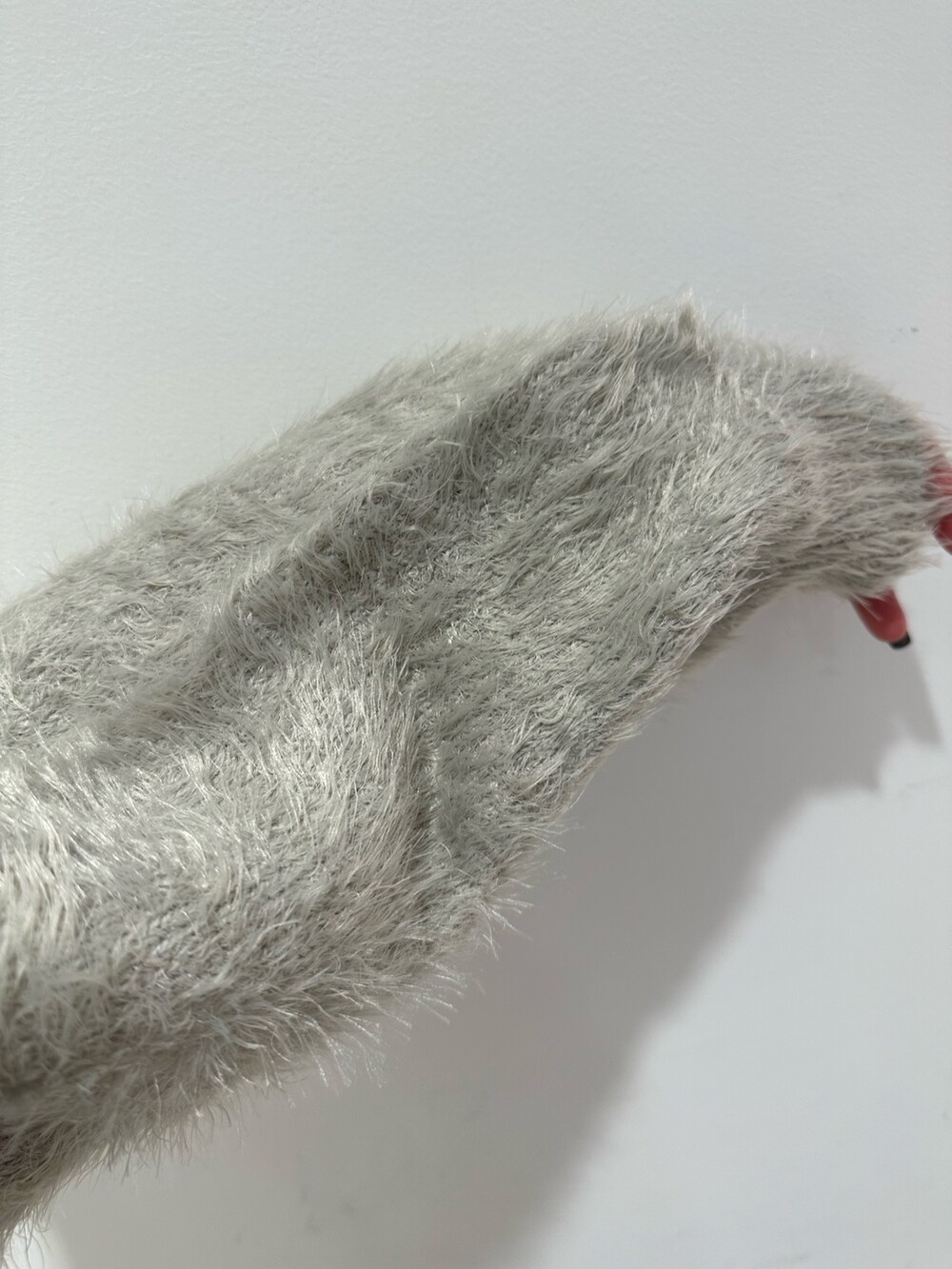 ブラウン系のスカート、グレー系のニット/セーター、ホワイト系のブーツを着用したレディースの冬コーディネートの5枚目の写真