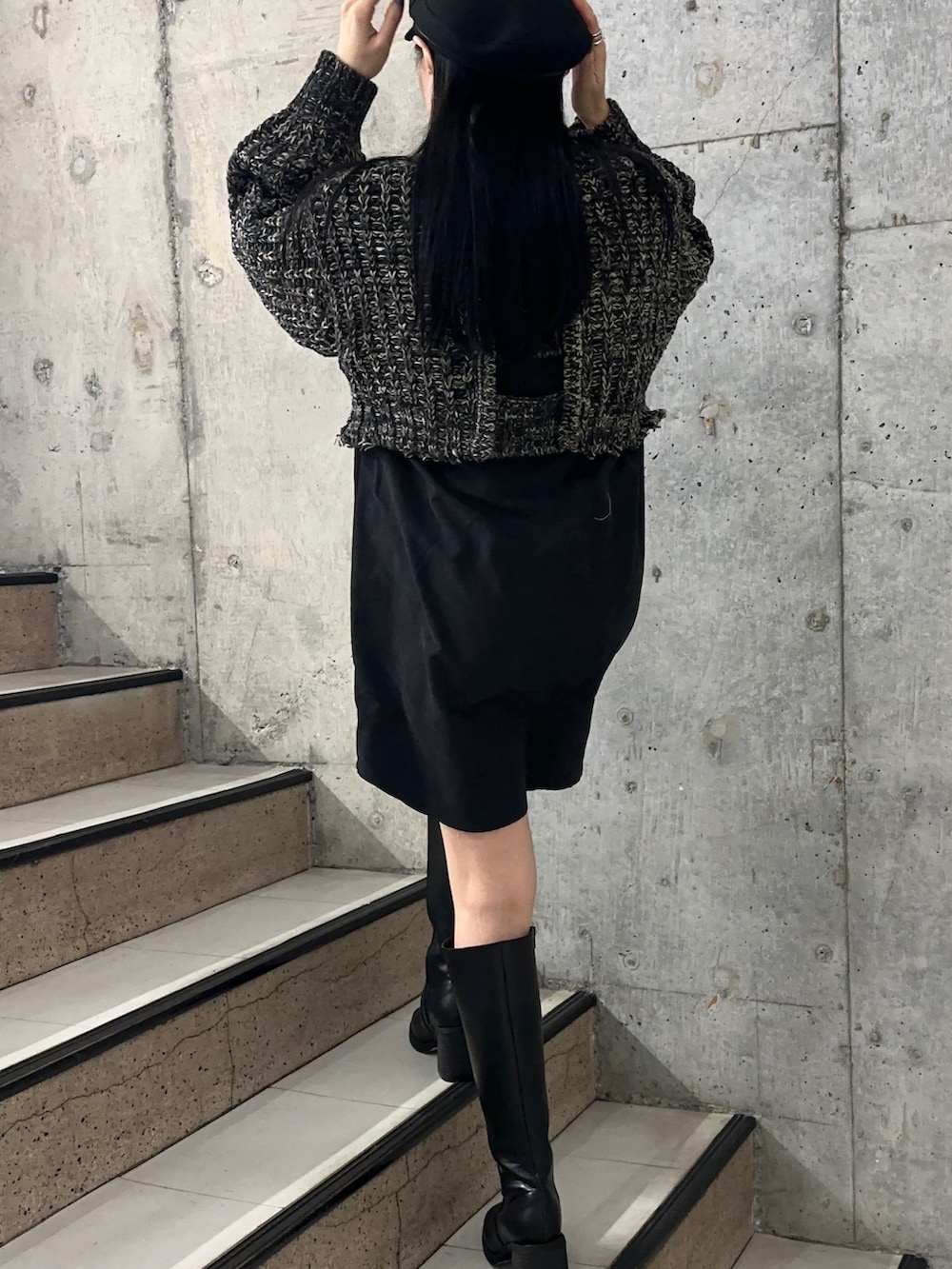 ブラック系のワンピース、ブラック系のブーツを着用したレディースの秋コーディネートの2枚目の写真