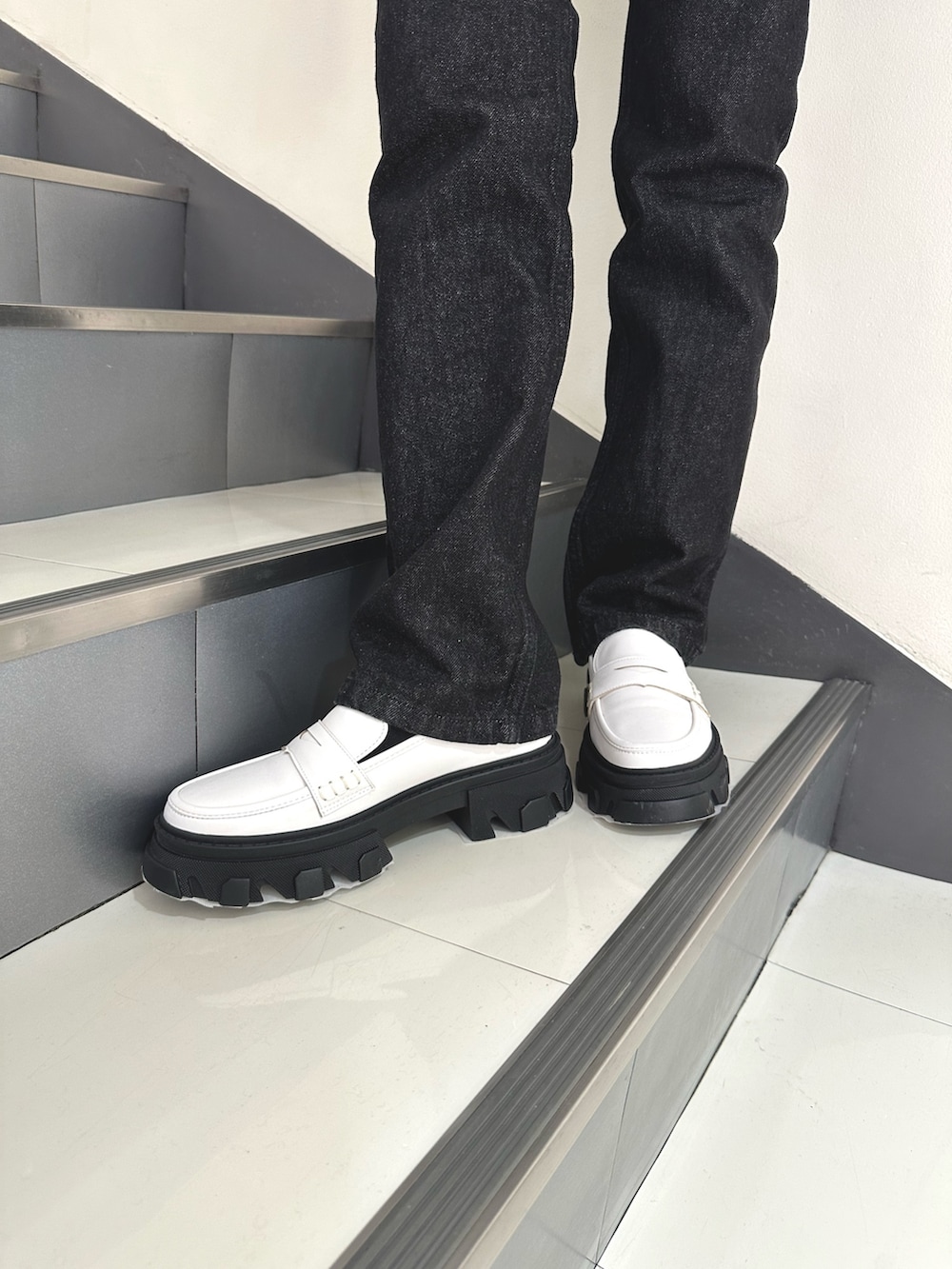 イエロー系のカーディガン/ボレロ、ブラック系のデニムパンツ、ホワイト系のローファーを着用したレディースの冬コーディネートの7枚目の写真