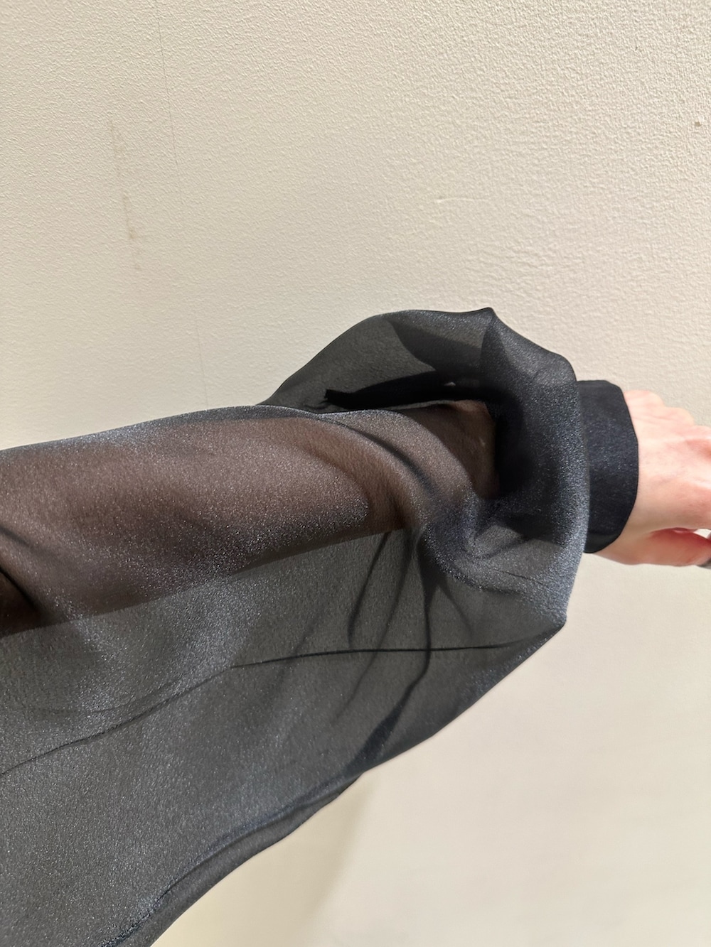 ブラック系のニット/セーター、ブルー系のデニムパンツを着用したレディースの春コーディネートの5枚目の写真