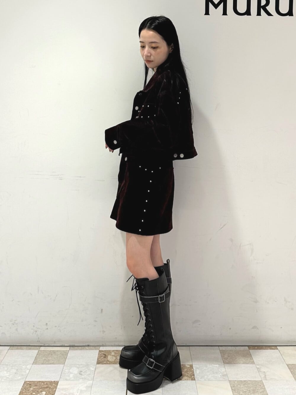 レッド系のスカート、レッド系のデニムジャケット、ブラック系のブーツを着用したレディースの夏コーディネートの3枚目の写真