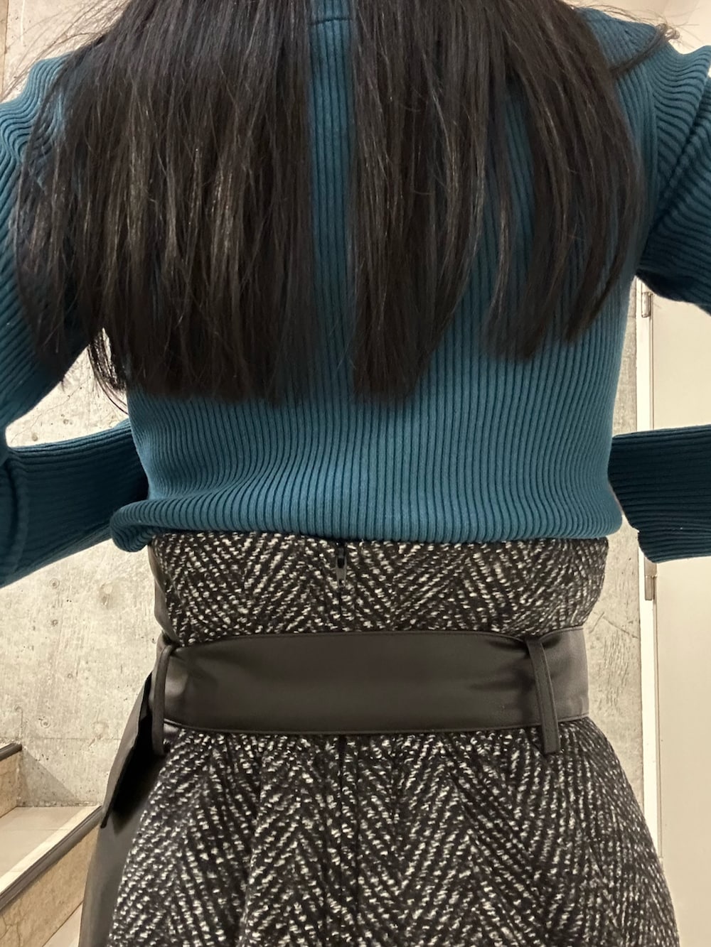 ブラック系のスカート、ブルー系のニット/セーター、ブラック系のブーツを着用したレディースの秋コーディネートの7枚目の写真