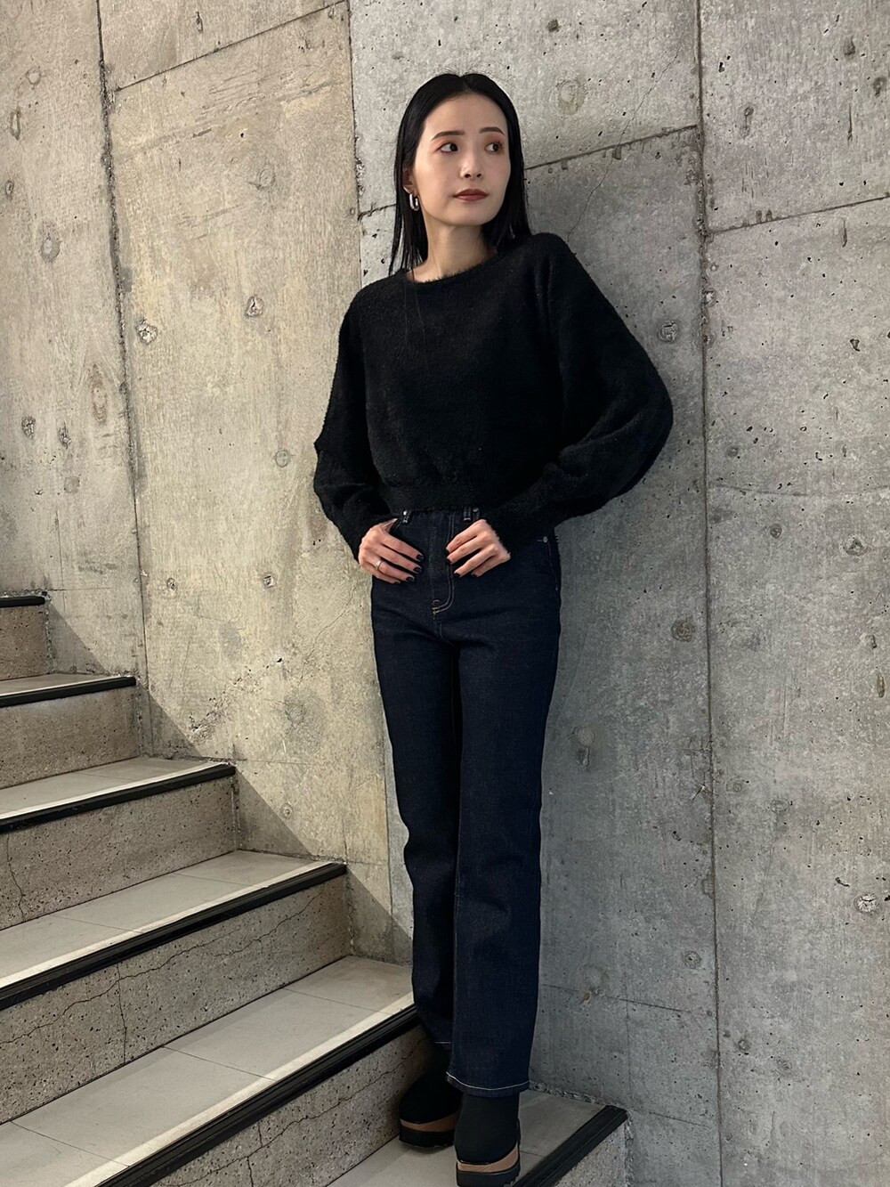 ブラック系のチェスターコート、ブラック系のブーツ、ブラック系のニット/セーターを着用したレディースの秋コーディネートの4枚目の写真