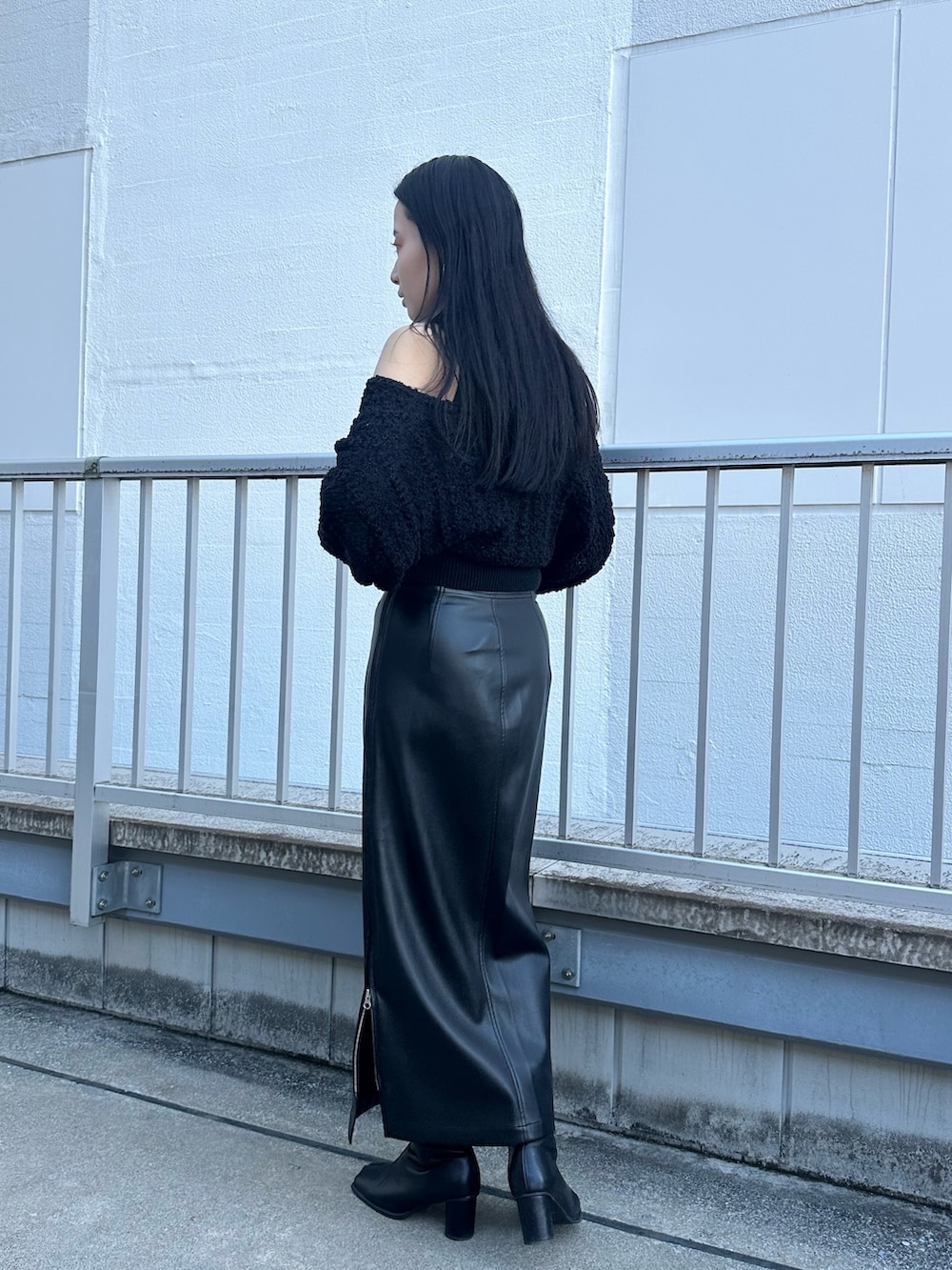 ブラック系のニット/セーター、ブラック系のスカートを着用したレディースの秋コーディネートの4枚目の写真