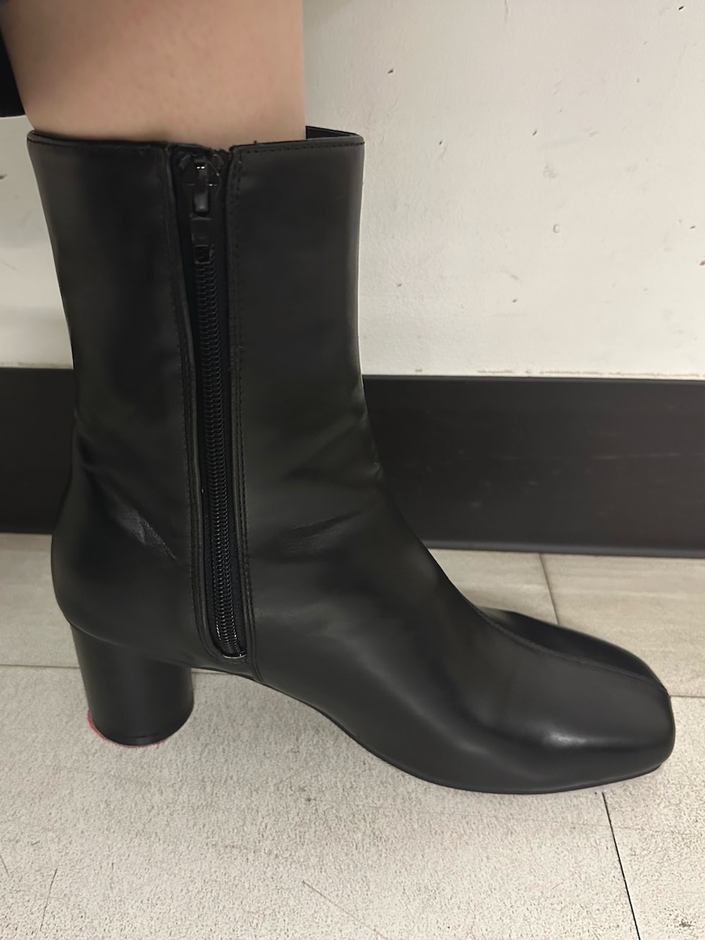 グレー系のスラックス、ブラック系のブーツ、グレー系のテーラードジャケットを着用したレディースの秋コーディネートの8枚目の写真