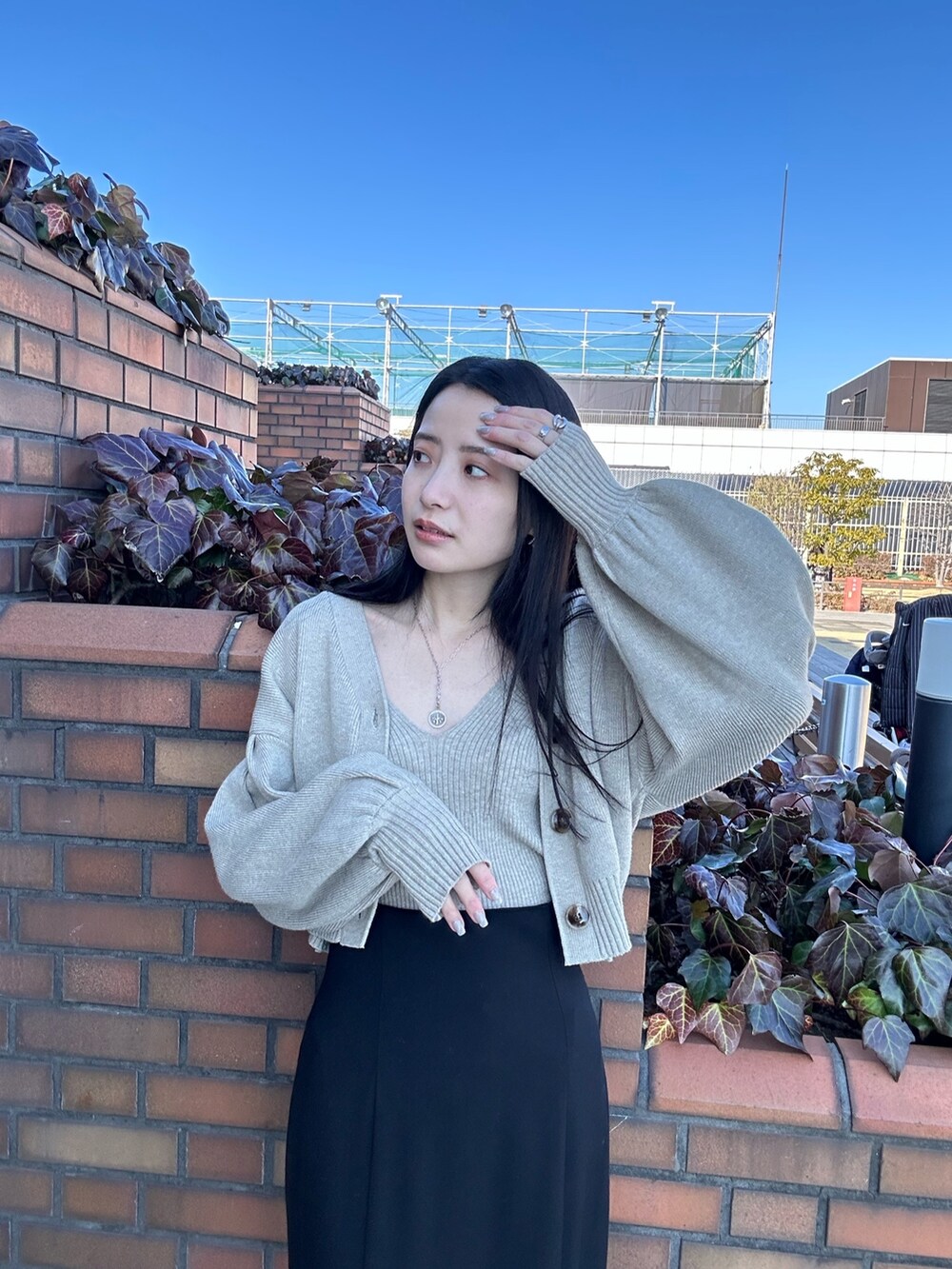 ホワイト系のカーディガン/ボレロ、ブラック系のスカートを着用したレディースの冬コーディネートの4枚目の写真