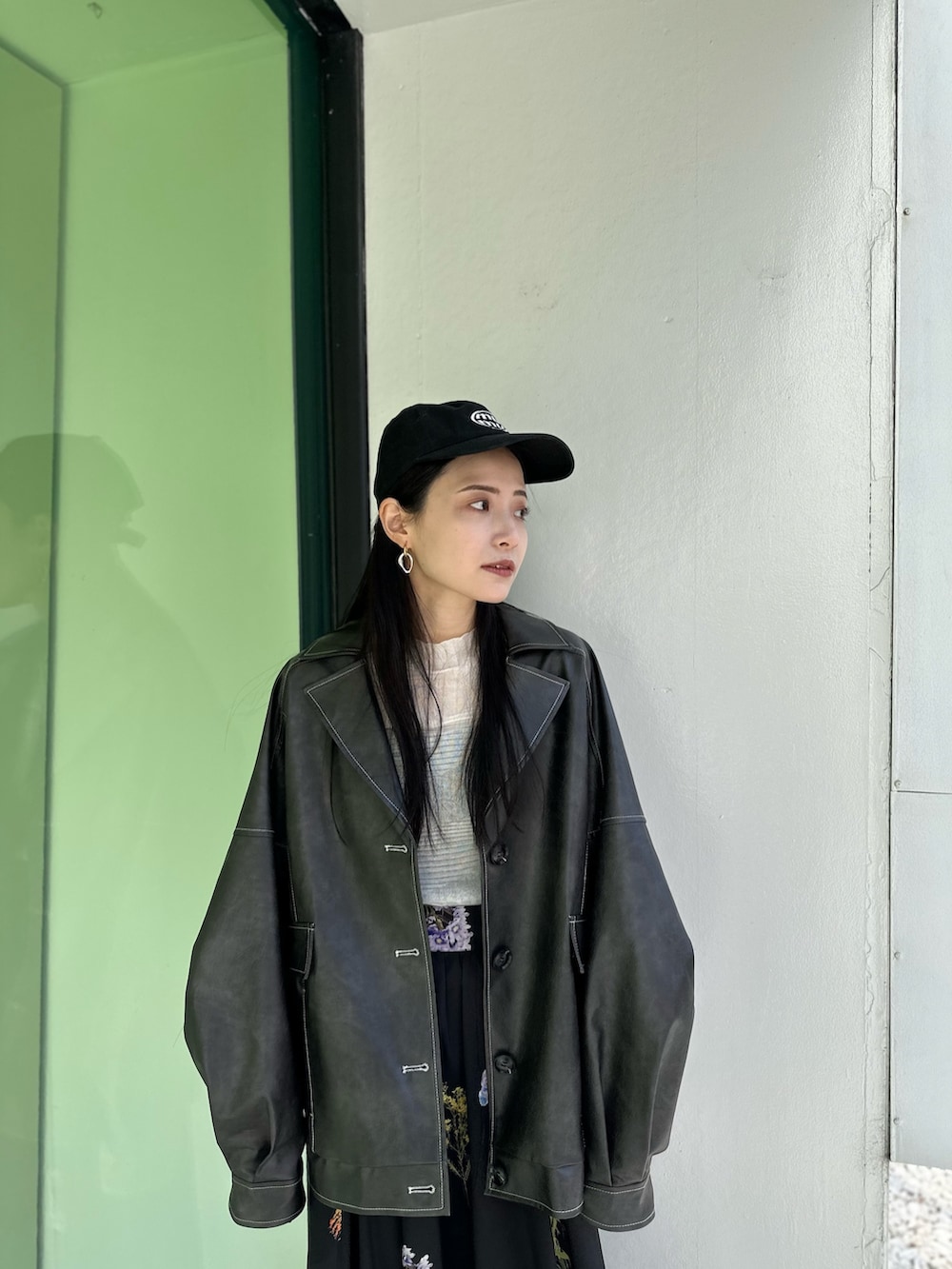 グレー系のブルゾン、ブラック系のスカート、ブラック系のブーツを着用したレディースの冬コーディネートの8枚目の写真