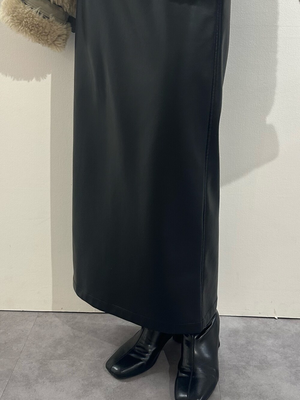 ブラック系のスカート、ブラウン系のムートンコート、レッド系のニット/セーターを着用したレディースの冬コーディネートの6枚目の写真