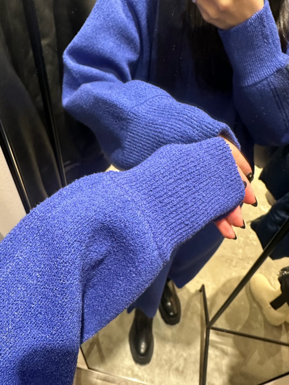 ブルー系のニット/セーター、ブルー系のスカート、ブラック系のブーツを着用したレディースの冬コーディネートの6枚目の写真