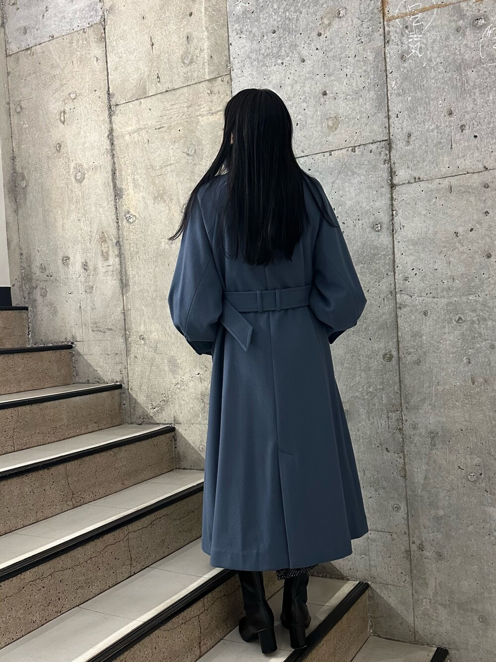 ブルー系のステンカラーコート、ブラック系のブーツを着用したレディースの秋コーディネートの3枚目の写真