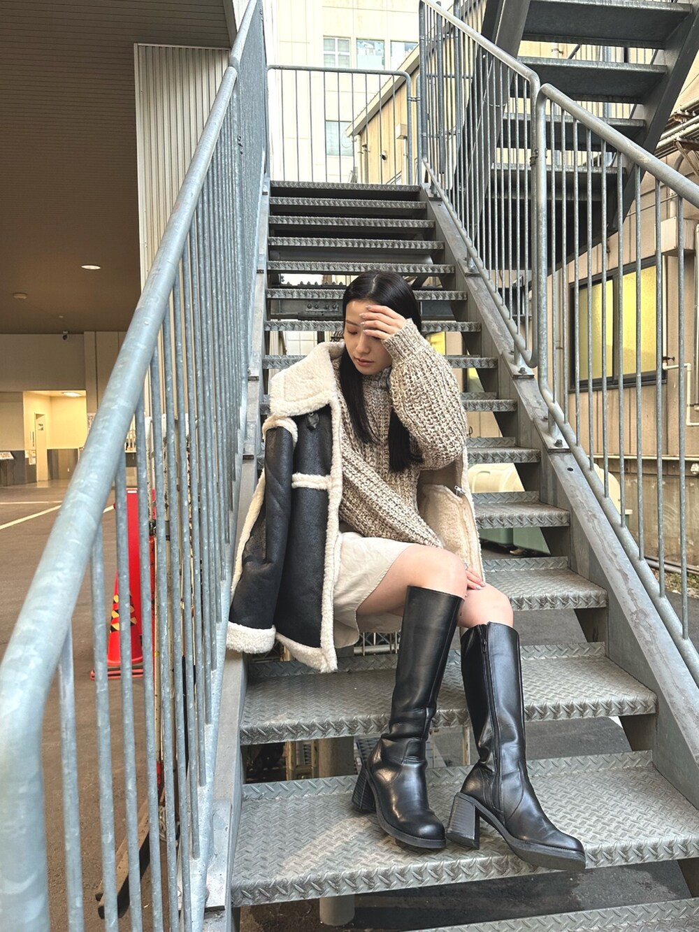 ホワイト系のワンピース、ブラック系のムートンコートを着用したレディースの冬コーディネートの3枚目の写真