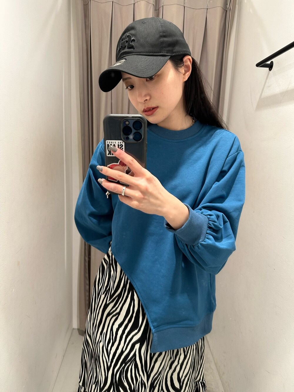 ブルー系のTシャツ/カットソー、ホワイト系のスカート、ブラック系のキャップを着用したレディースの春コーディネートの4枚目の写真