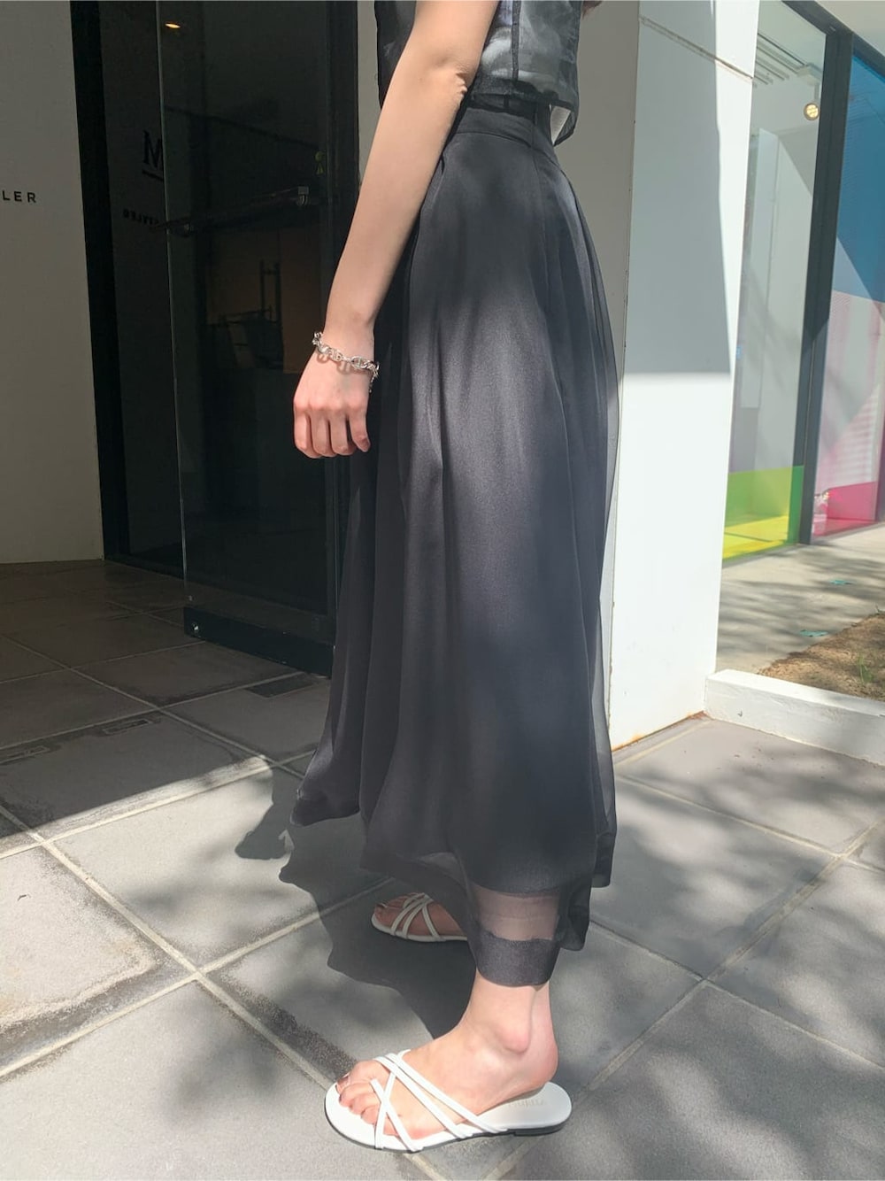ホワイト系のサンダル、ブラック系のスカート、ブラック系のTシャツ/カットソーを着用したレディースの夏コーディネートの5枚目の写真
