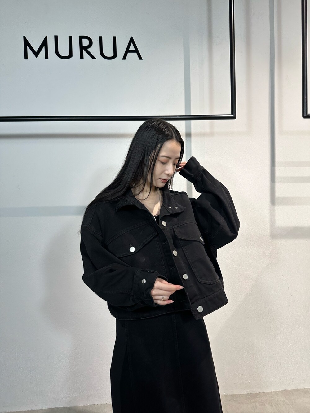 ブラック系のワンピース、ブラック系のデニムジャケット、ブラック系のブーツを着用したレディースの冬コーディネートの8枚目の写真