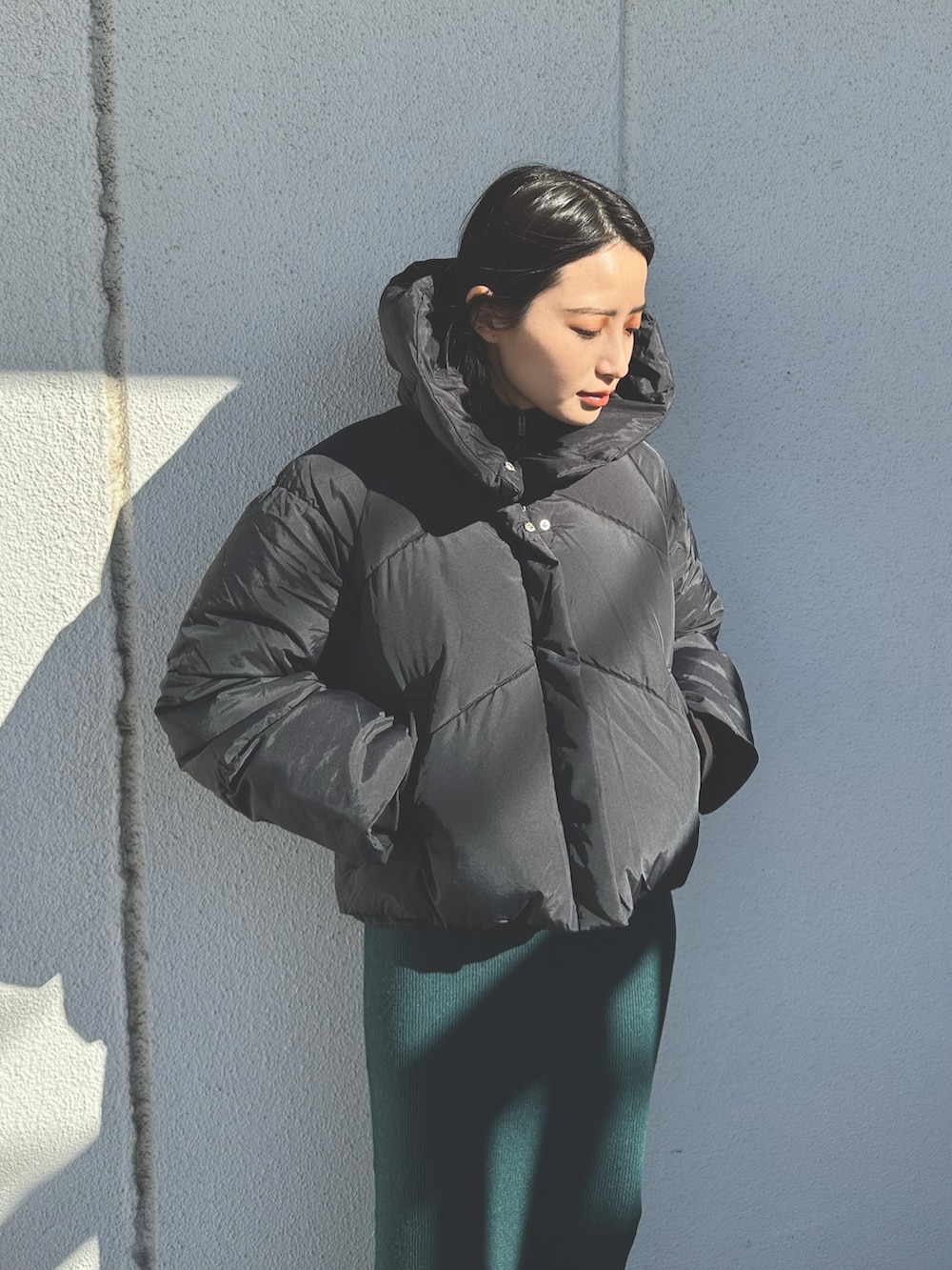 ブラック系のダウンジャケット/コート、グリーン系のワンピース、ブラック系のブーツを着用したレディースの秋コーディネートの3枚目の写真