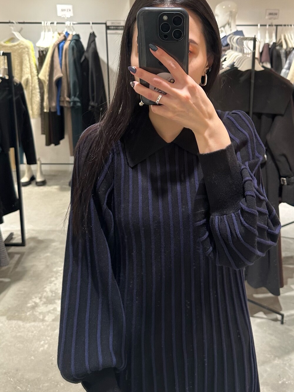 ブラック系のダウンジャケット/コート、ブラック系のブーツ、ブラック系のワンピースを着用したレディースの冬コーディネートの8枚目の写真