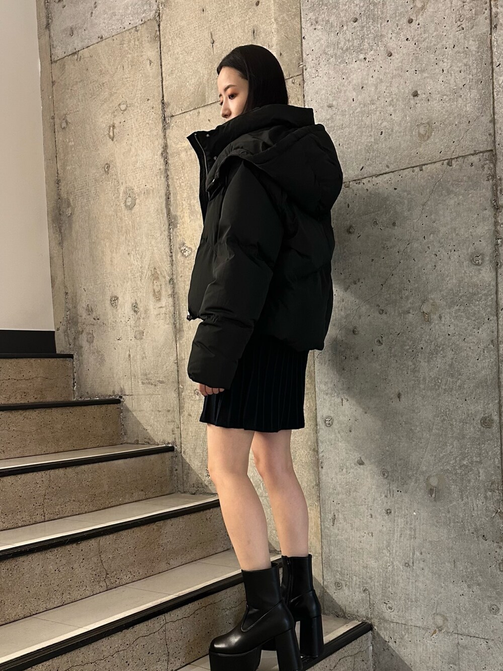 ブラック系のダウンジャケット/コート、ブラック系のブーツ、ブラック系のワンピースを着用したレディースの冬コーディネートの3枚目の写真