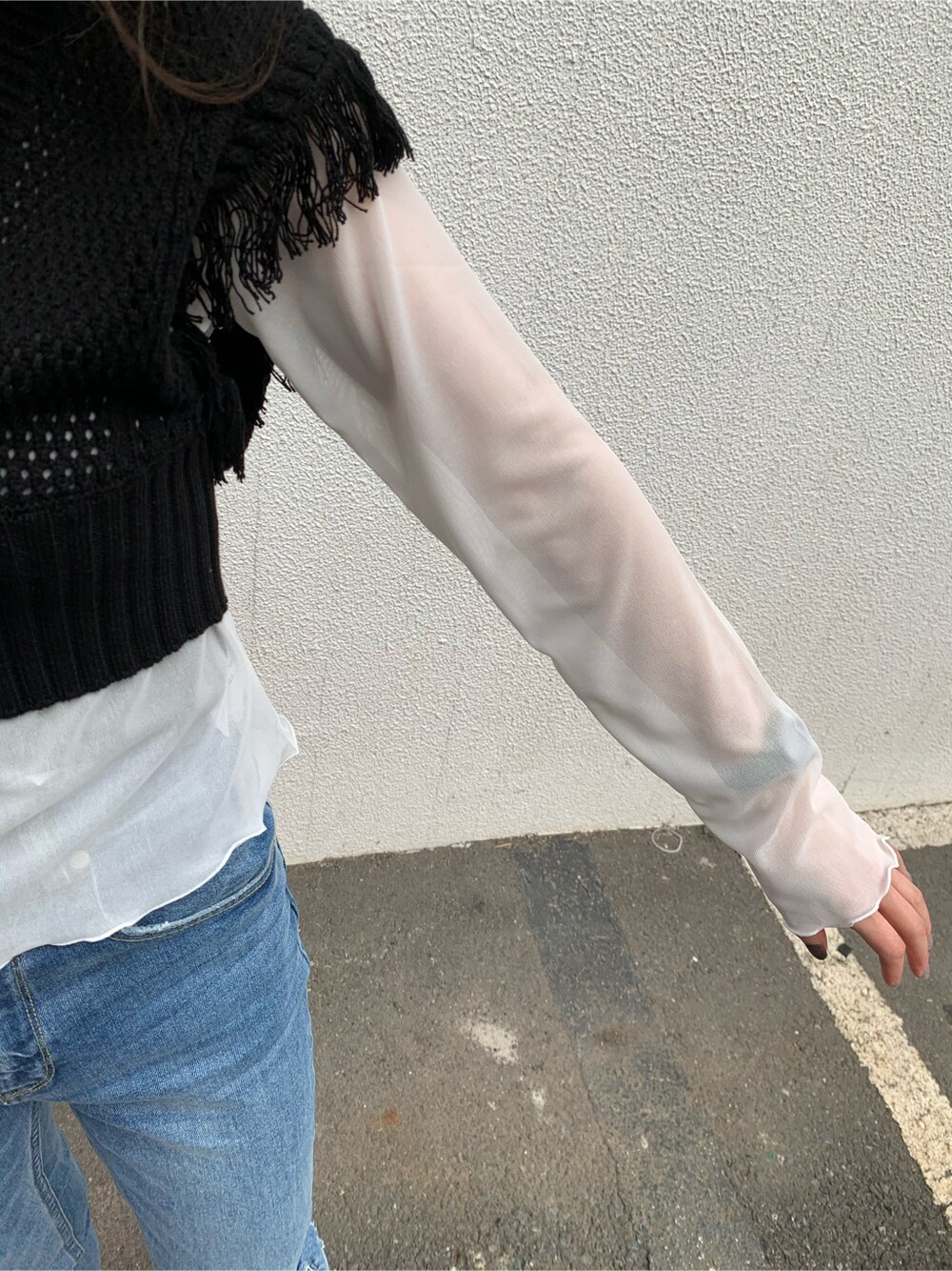 ブルー系のデニムパンツ、ブラック系のサンダル、ブラック系のニット/セーターを着用したレディースの春コーディネートの4枚目の写真