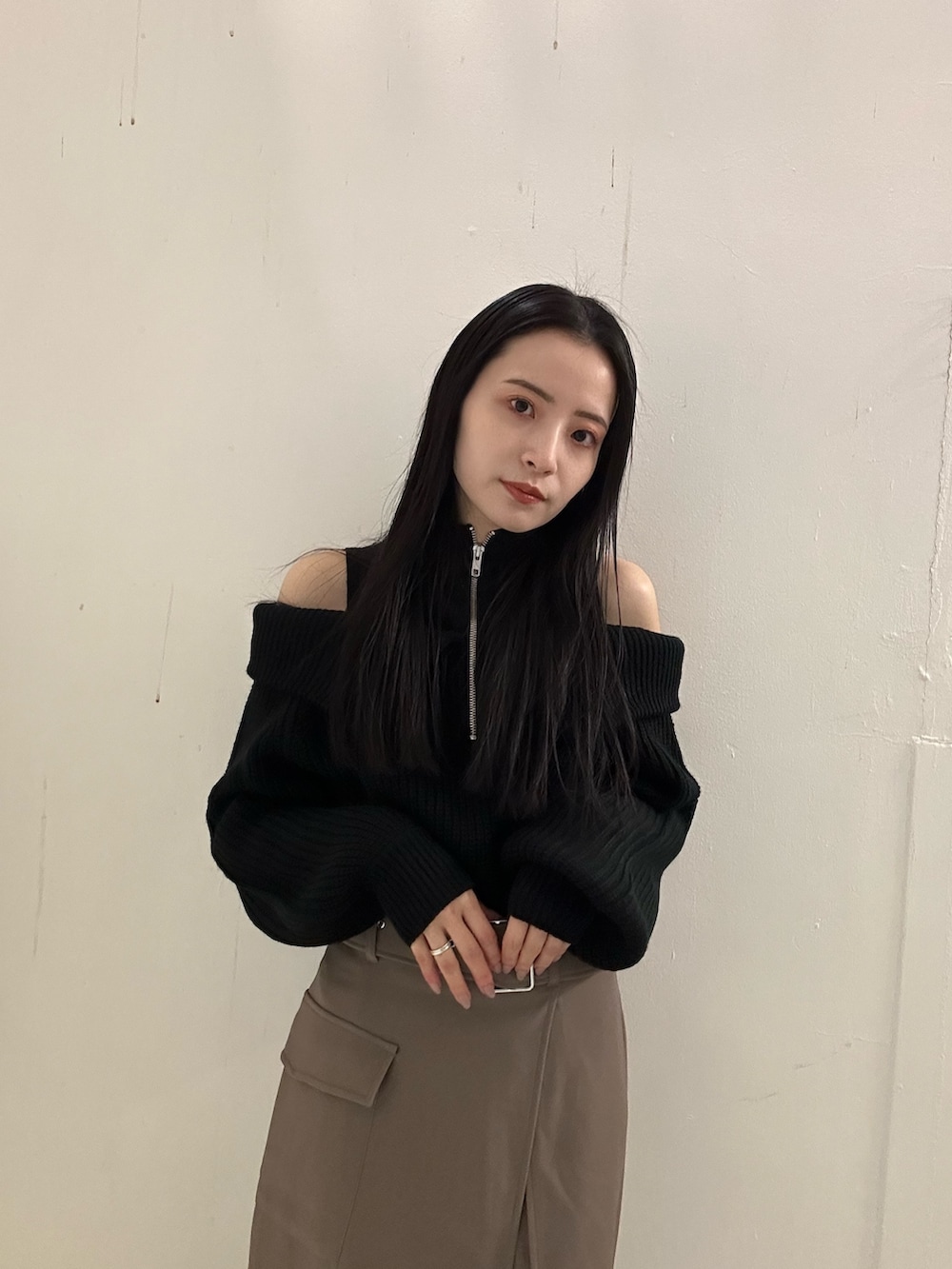 ブラウン系のスカート、ブラック系のニット/セーター、ブラック系のブーツを着用したレディースの冬コーディネートの4枚目の写真