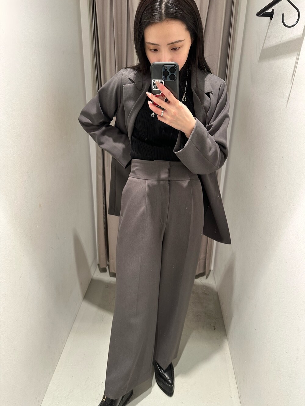 グレー系のスラックス、グレー系のテーラードジャケット、ブラック系のローファーを着用したレディースの冬コーディネートの2枚目の写真