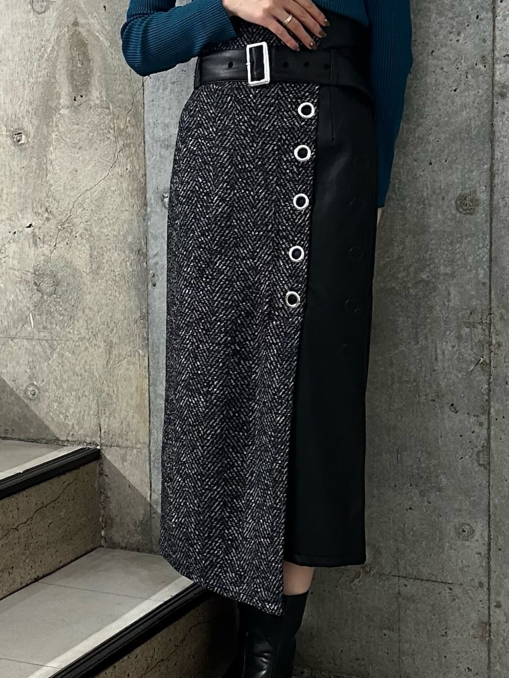 ブラック系のスカート、ブルー系のニット/セーター、ブラック系のブーツを着用したレディースの秋コーディネートの4枚目の写真