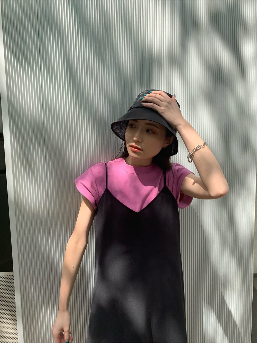 ピンク系のタンクトップ、ブラック系のワンピース、ブラック系のサンダルを着用したレディースの夏コーディネートの3枚目の写真