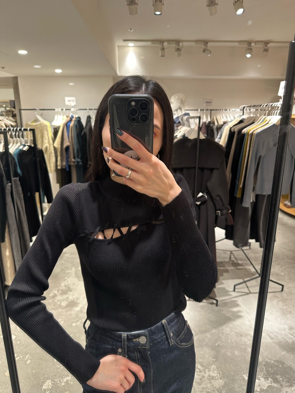 ブラック系のブーツ、ブラック系のチェスターコート、ブラック系のニット/セーターを着用したレディースの冬コーディネートの6枚目の写真