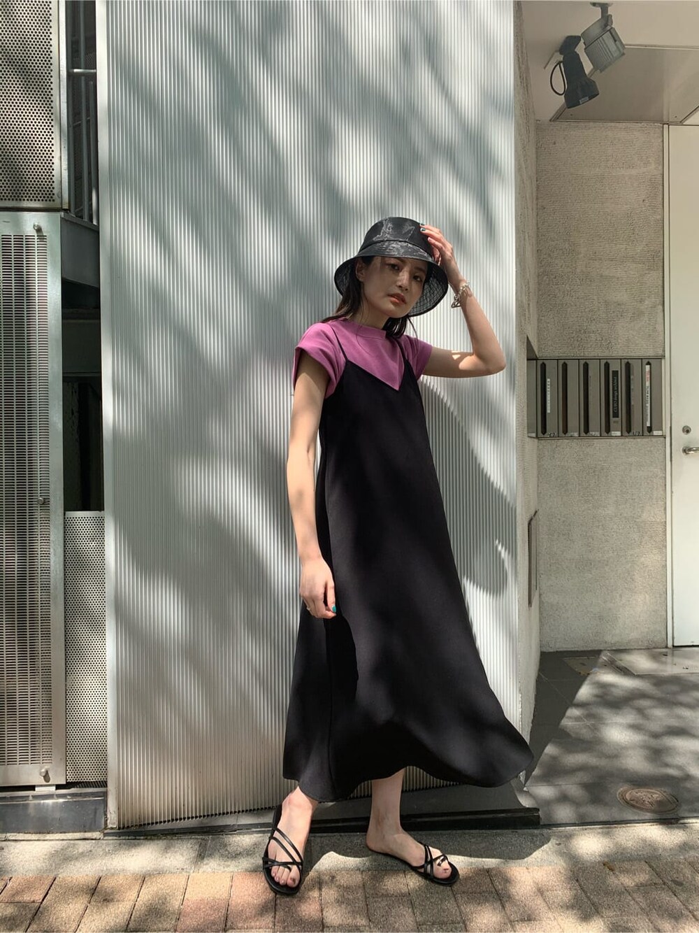 ピンク系のタンクトップ、ブラック系のワンピース、ブラック系のサンダルを着用したレディースの夏コーディネートの2枚目の写真